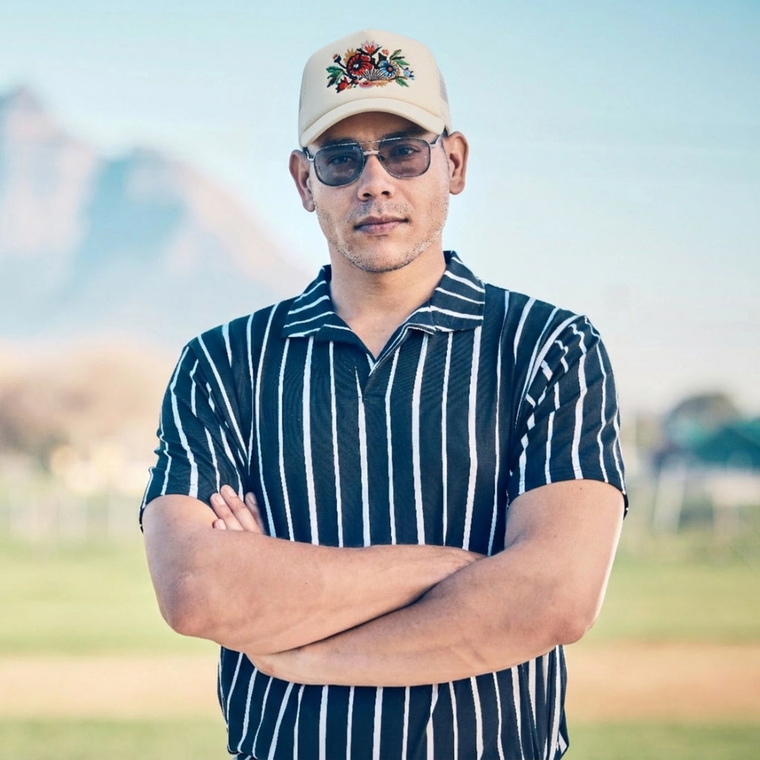 Man Wearing A Striped shirt And Floral Artwork Trucker Cap Jet Stream by AREE Apparel streetwear brand